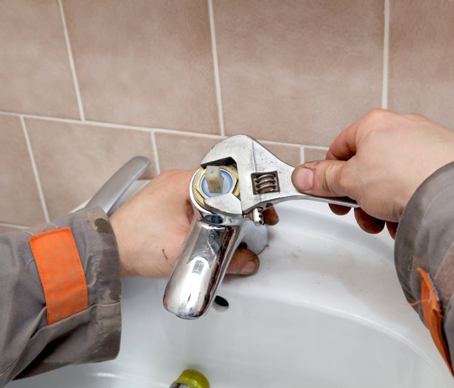 Plumber Fixing Water Tap in a Bathroom Using Spanner in Bathurst, NSW