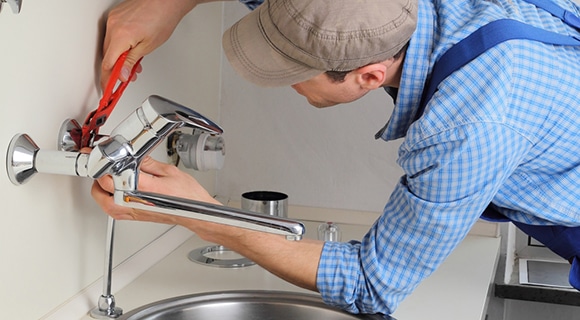 A Plumber Repairing Tap in a Kitchen in Oberon, NSW