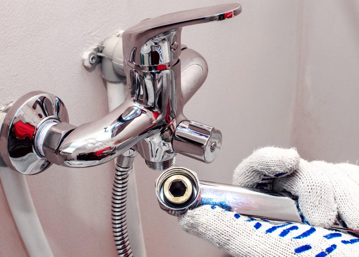 Plumber Hands in Gloves Are Fixing Bath Tap Into Place in Bathurst, NSW