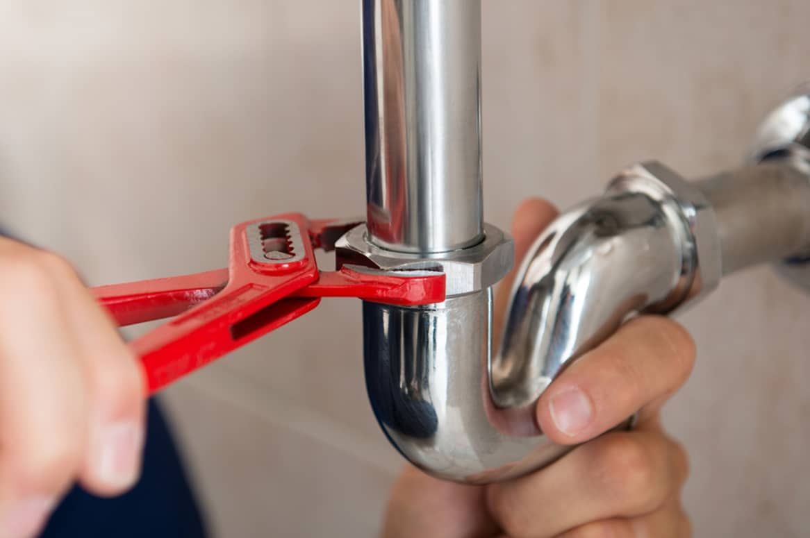 Plumber Fixing Pipe With Wrench in Bathurst, NSW