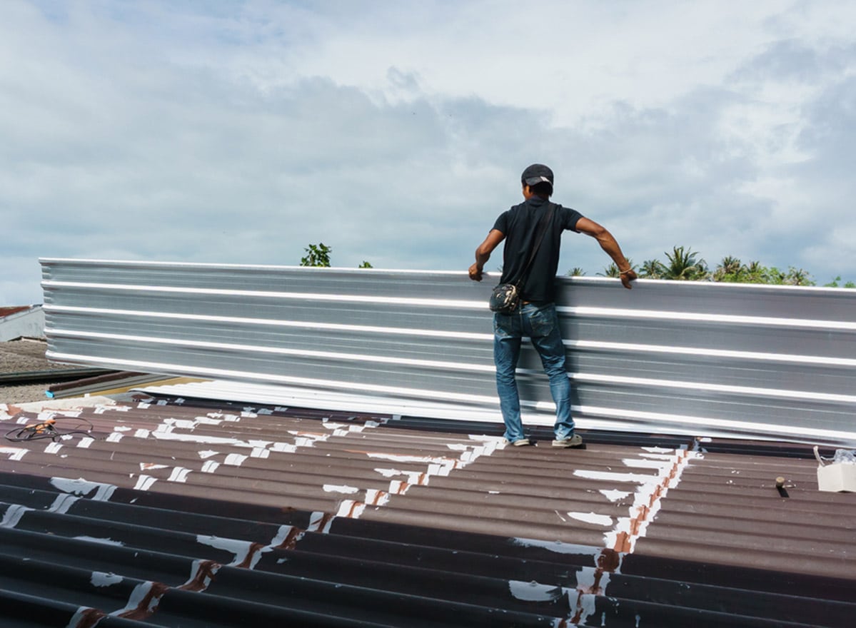 Worker Installing Metal Sheet Roof - Roofing and Guttering Services in Oberon, NSW