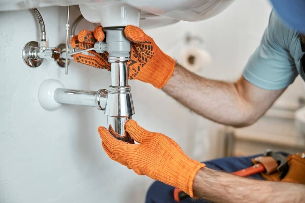 Male Plumber Hands Fixing Metal Sink Pipe - Emergency Plumbing Services In Orange, NSW