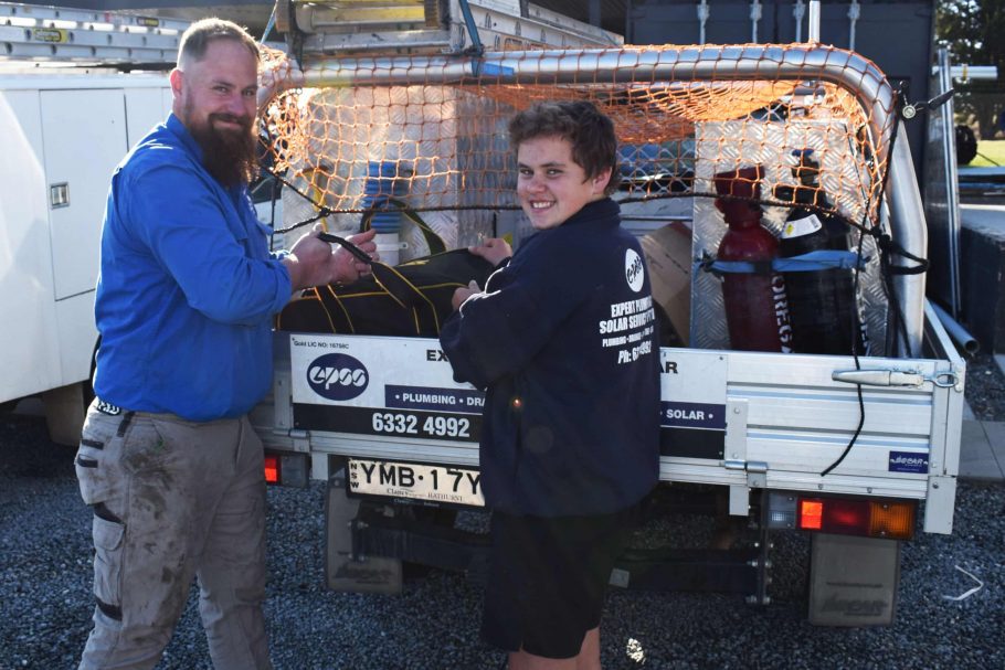 Company Owner and Son in Uniforms Smiling in front of Company Vehicle- Emergency Plumbing Services In Orange, NSW